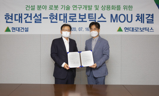 박구용(왼쪽) 현대건설 기술연구소장과 윤대규(오른쪽) 현대로보틱스 로봇연구소장이 기념촬영을 하고 있다.   현대건설 제공